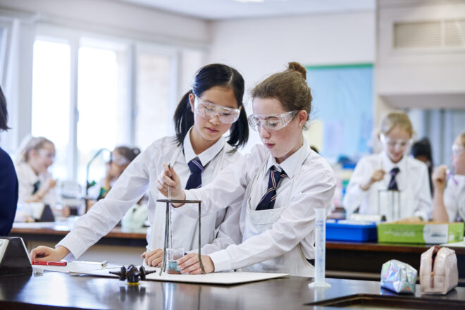 Two students in a chemistry lab class conduct an experiement